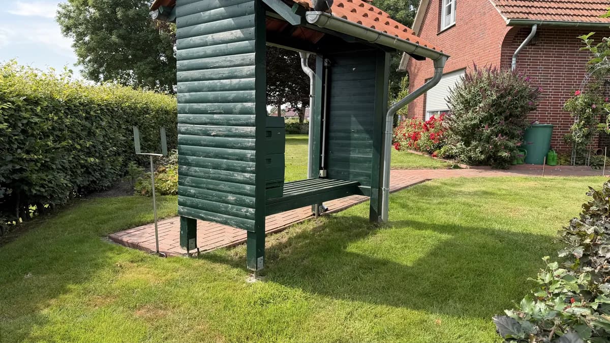 Bienenstand mit grünen Beuten im Garten